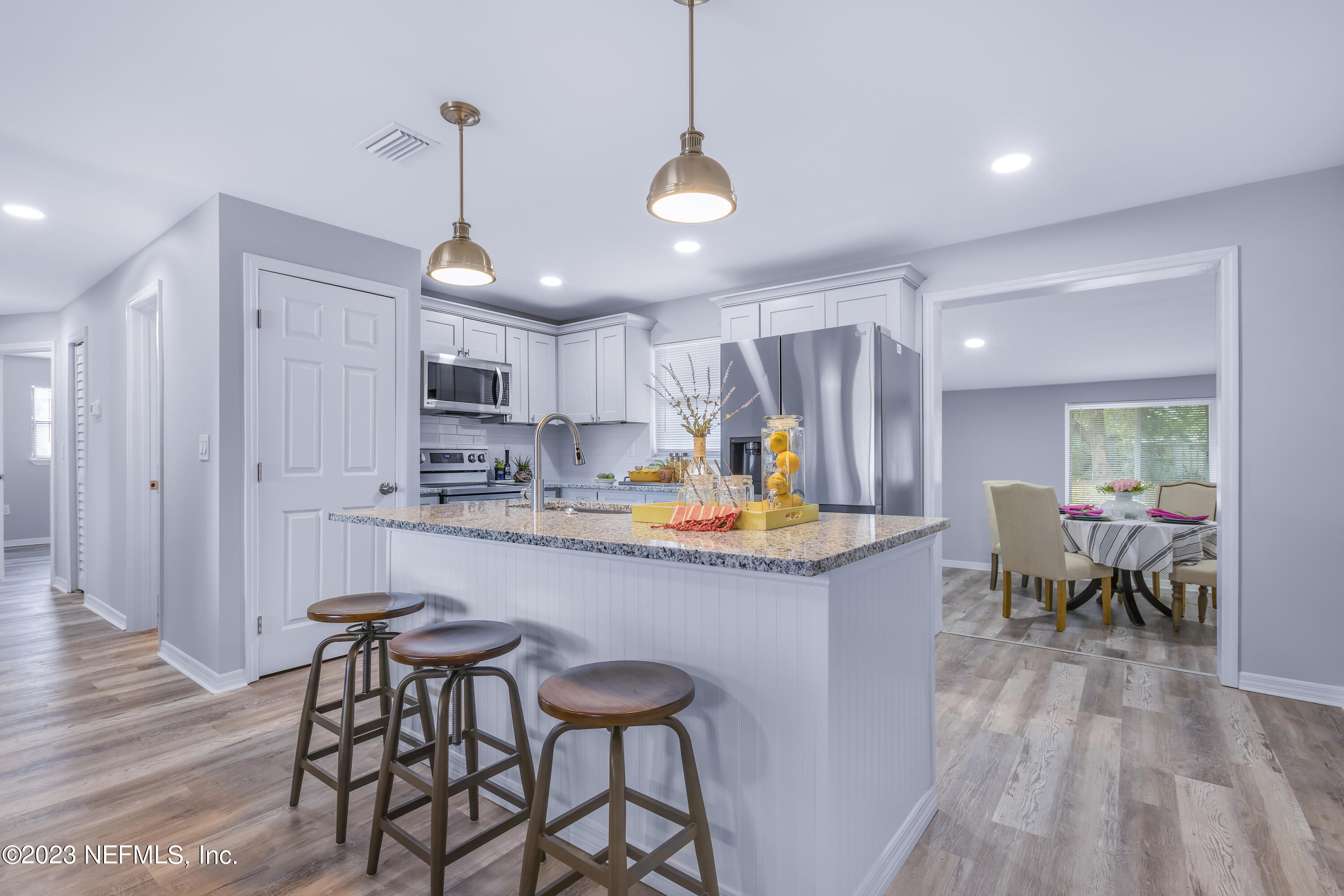 295 Edson Drive Orange Park, FL 32073 - Photo 5 of 37 a kitchen with stainless steel appliances granite countertop a sink a stove a refrigerator and island with wooden floor