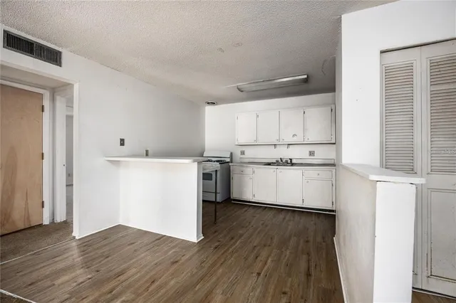 a kitchen with wooden floors and white appliances