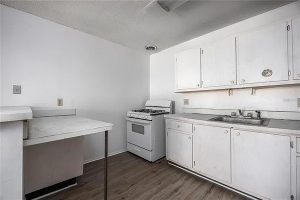 a kitchen with granite countertop white cabinets and white appliances