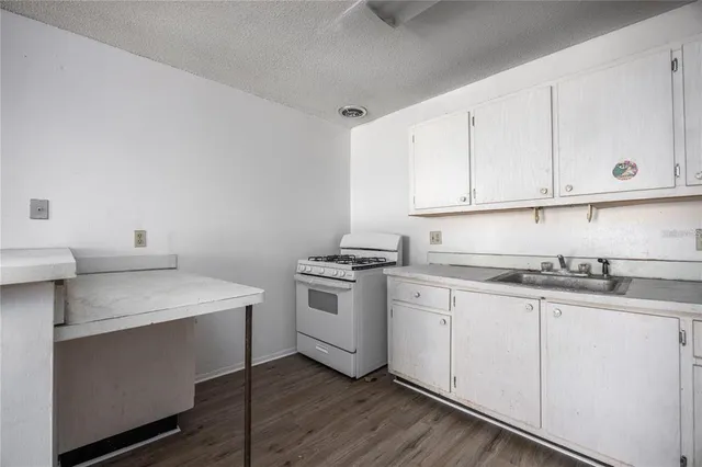 a kitchen with granite countertop white cabinets and white appliances
