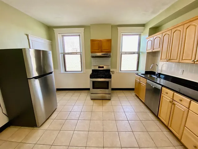 a kitchen with a refrigerator a stove a sink and a window
