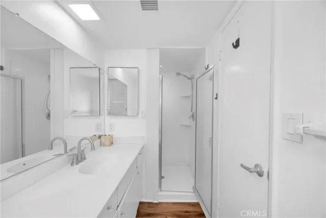 a bathroom with a shower sink and mirror