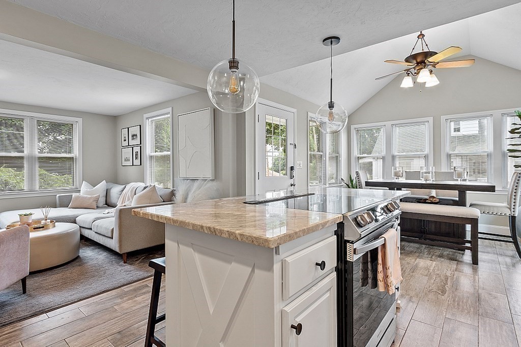 42 Ancona Road Worcester, MA 01604 - Photo 15 of 38 a open kitchen with stainless steel appliances granite countertop a stove a refrigerator a kitchen island a couches and couches with wooden floor