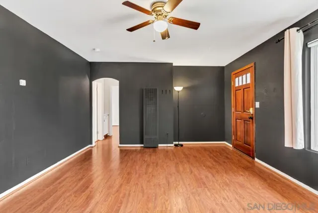 a view of a livingroom with a chandelier fan and windows