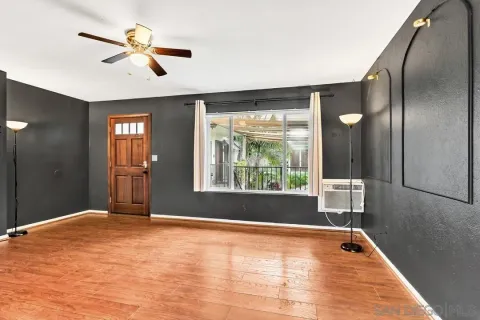 a view of empty room with window and ceiling fan