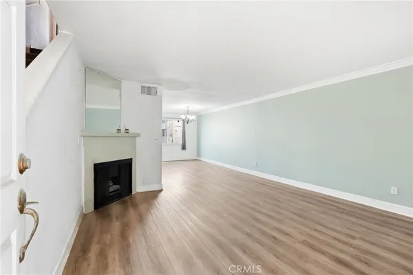 a view of a livingroom with wooden floor and a fireplace
