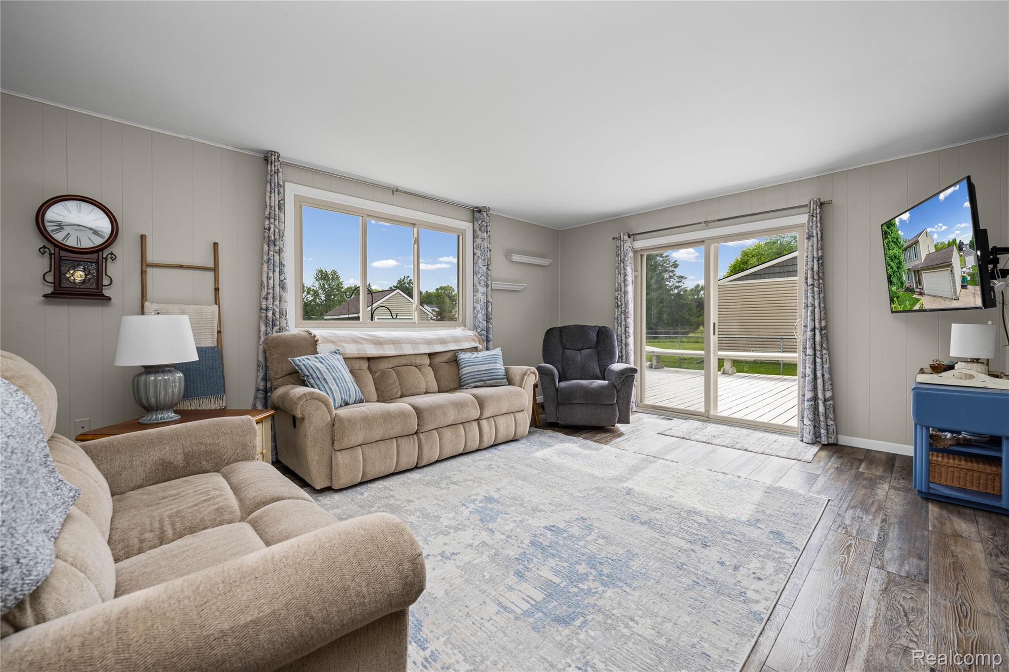 3553 Loon Lake Road Wixom, MI 48393 - Photo 9 of 25 Spacious living area featuring wood-finish flooring, a neutral color palette, and vertical paneling