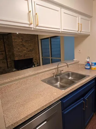 a kitchen with granite countertop a sink and cabinets