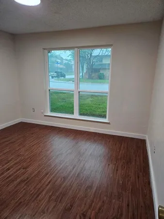 a view of a room with wooden floor and window