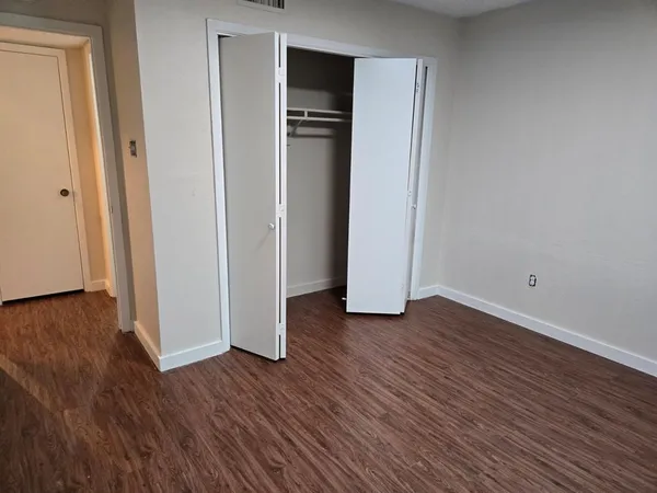 a view of empty room with wooden floor