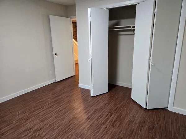 an empty room with wooden floor and closet