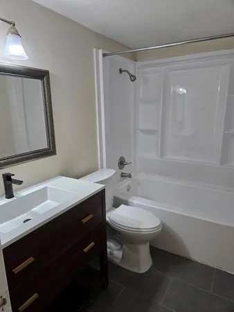 a bathroom with a sink toilet a mirror and shower