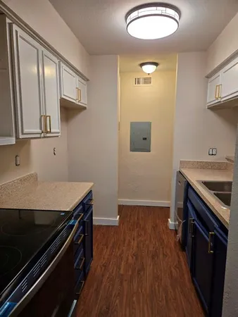 a kitchen with a stove and a wooden floor