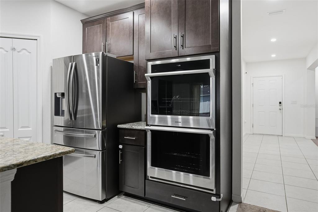 13286 Pendleton Street Spring Hill, FL 34609 - Photo 12 of 57 a metallic refrigerator freezer and a stove sitting inside of a kitchen