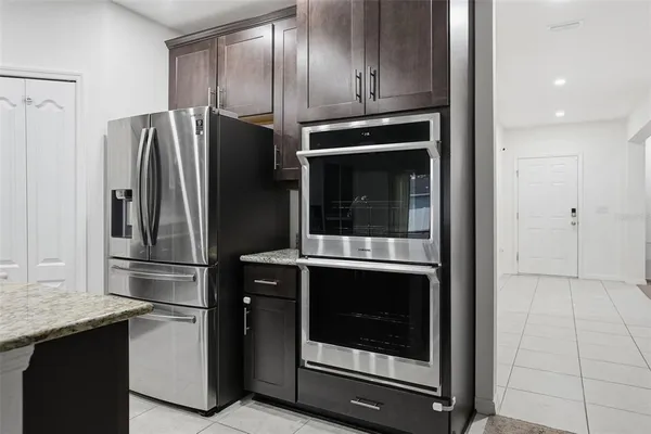 a living room with furniture a dining table and a refrigerator
