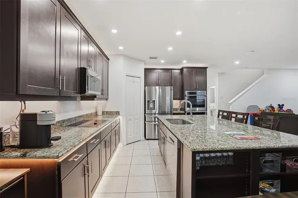 a kitchen with stainless steel appliances granite countertop a sink stove and cabinets