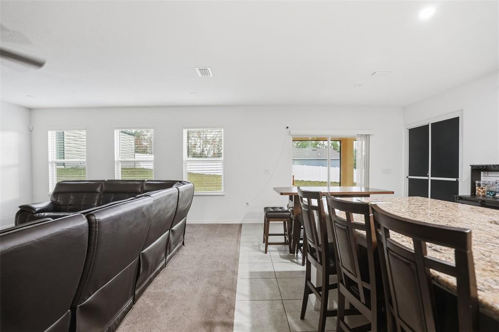 13286 Pendleton Street Spring Hill, FL 34609 - Photo 20 of 57 a living room with furniture a dining table and a refrigerator