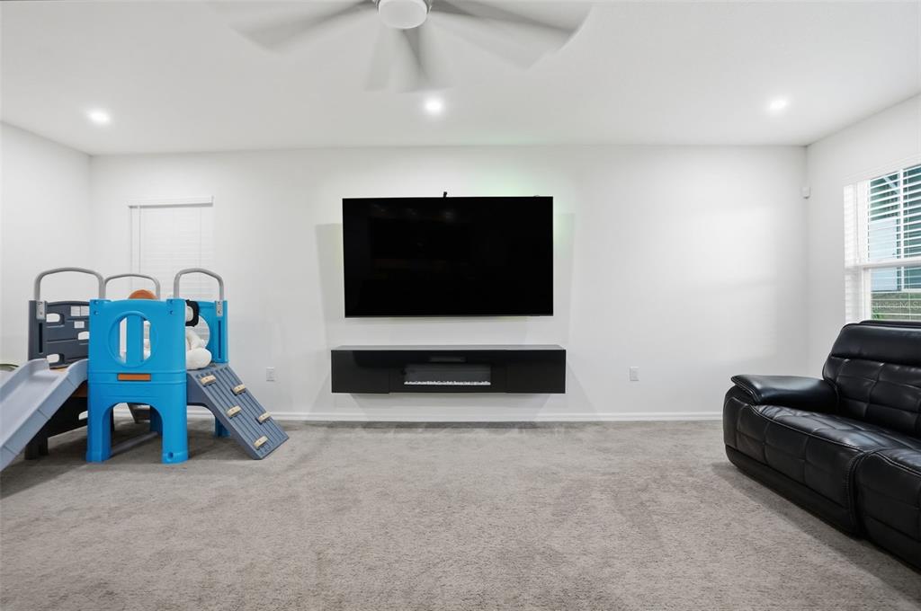 13286 Pendleton Street Spring Hill, FL 34609 - Photo 22 of 57 a living room with furniture gym equipment and a flat screen tv