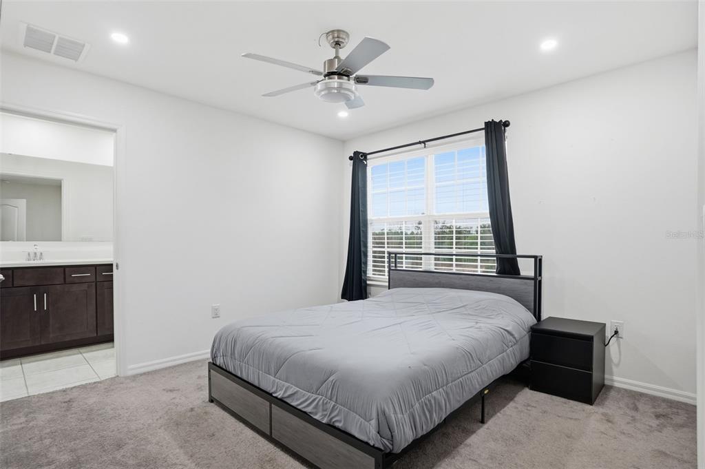 13286 Pendleton Street Spring Hill, FL 34609 - Photo 34 of 57 a bedroom with a large bed and a ceiling fan