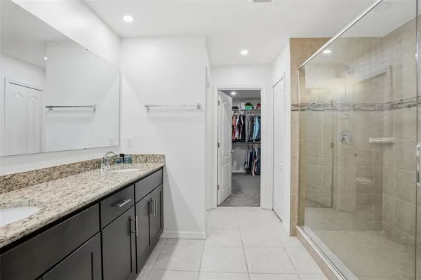 a metallic refrigerator freezer and a stove sitting inside of a kitchen