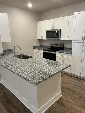 a kitchen with granite countertop a sink and a microwave