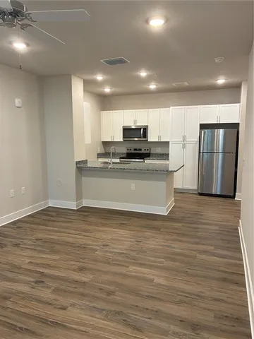 a view of kitchen with stainless steel appliances granite countertop a stove and a refrigerator