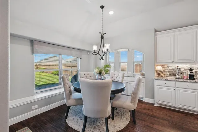 a dining room with furniture a chandelier and wooden floor