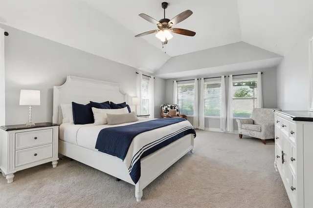 a spacious bedroom with a bed and a chandelier