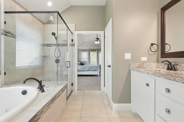 a bathroom with a granite countertop sink a mirror and shower