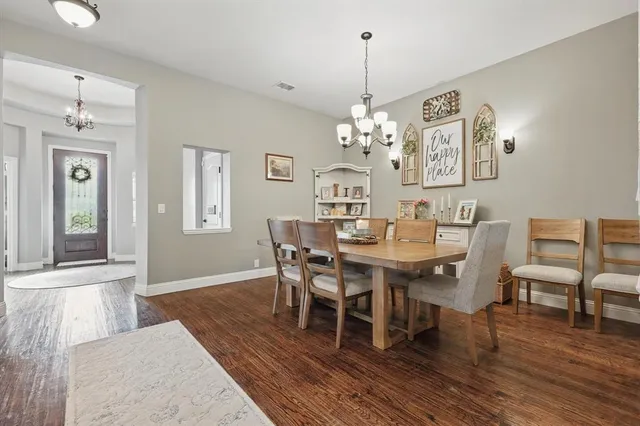 a view of a dining room with furniture wooden floor and chandelier