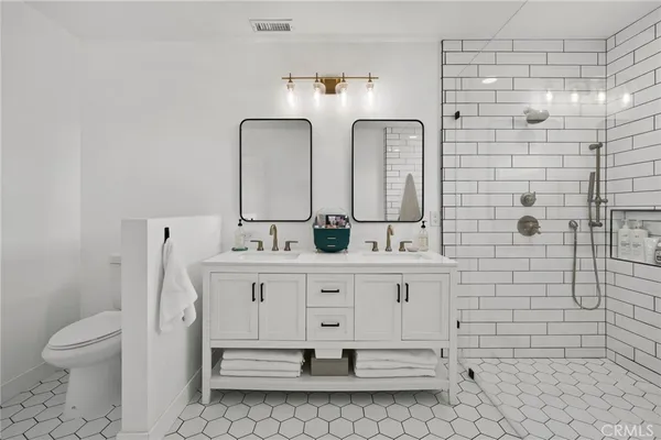 a bathroom with a double vanity sink mirror and toilet