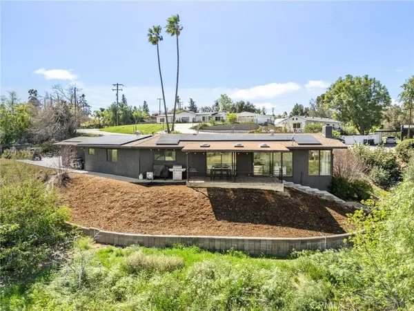 a view of house with a swimming pool and outdoor seating