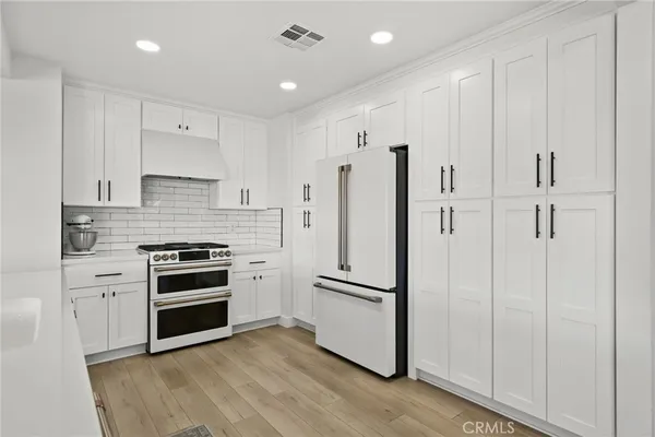 a kitchen with stainless steel appliances a refrigerator and a stove top oven