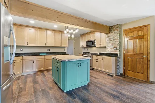 a kitchen with a refrigerator a sink dishwasher and white cabinets with wooden floor
