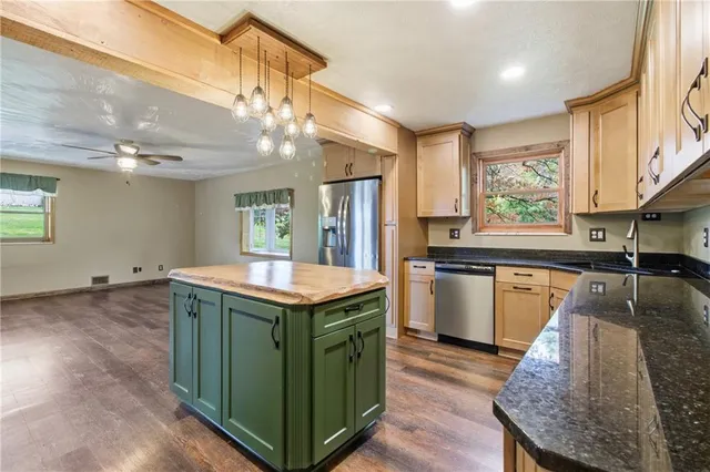 a kitchen with granite countertop cabinets stainless steel appliances and a sink