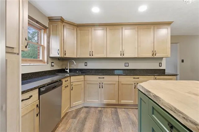 a kitchen with stainless steel appliances granite countertop a stove a microwave and a sink