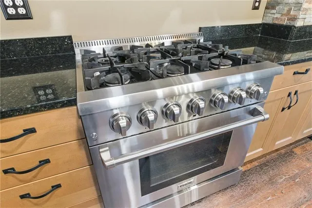 a kitchen with stainless steel appliances granite countertop a stove and a microwave