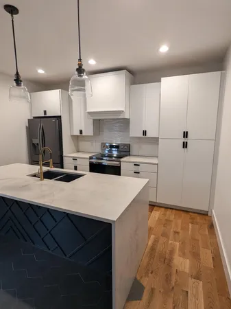 a kitchen with kitchen island a sink appliances and a counter top space