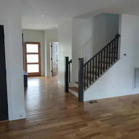 a view of a hallway with wooden floor and stairs