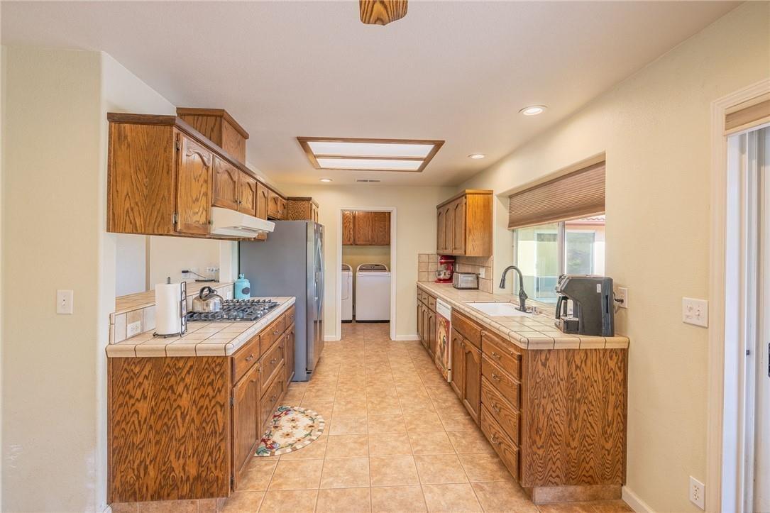 32057 River Knolls Road Coarsegold, CA 93614 - Photo 5 of 73 a kitchen with stainless steel appliances kitchen island granite countertop a sink and cabinets