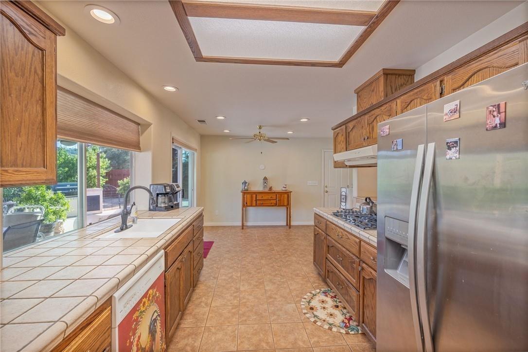 32057 River Knolls Road Coarsegold, CA 93614 - Photo 62 of 73 a kitchen with stainless steel appliances granite countertop a sink a stove and a refrigerator