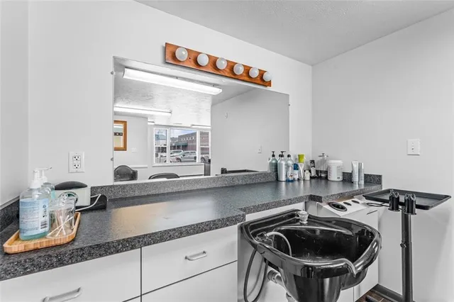 a kitchen with sink a stove and cabinets