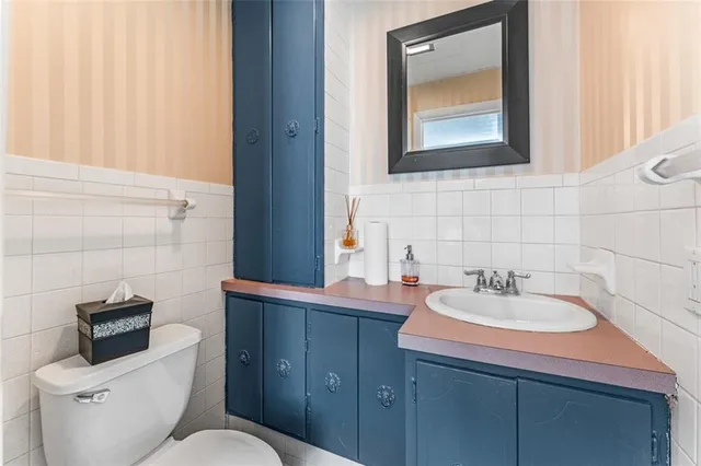 a bathroom with a toilet sink and mirror