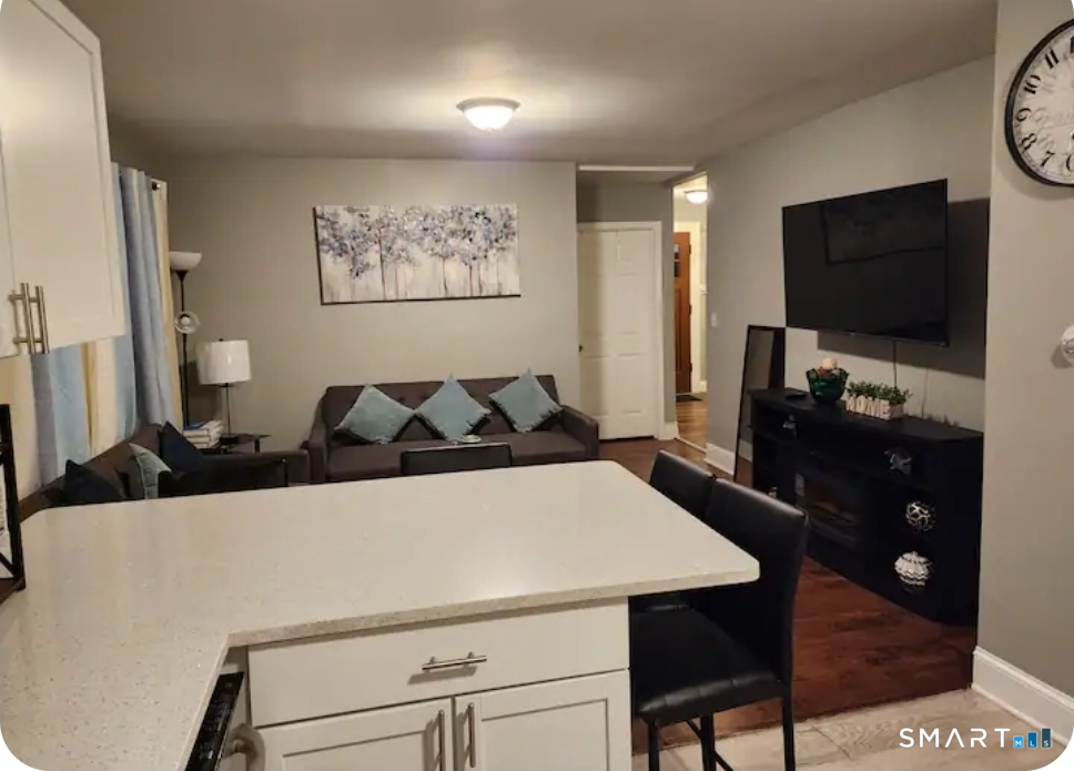 183 Harlem Avenue Bridgeport, CT 06606 - Photo 5 of 12 a living room with furniture a flat screen tv and kitchen view