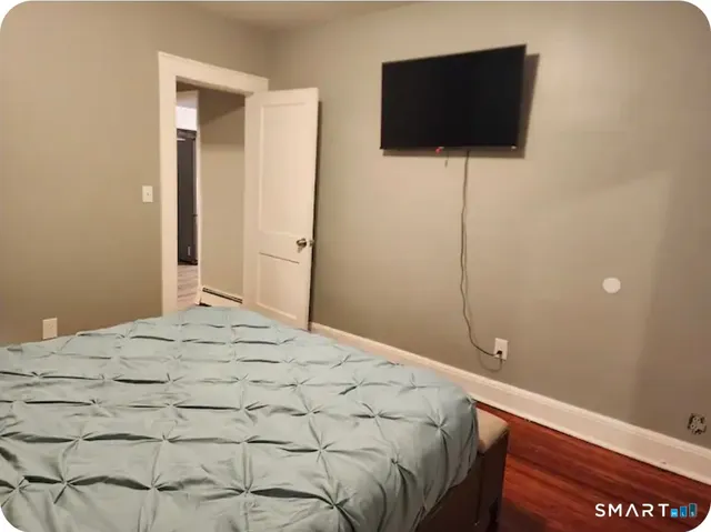 a bedroom with a bed and a flat screen tv