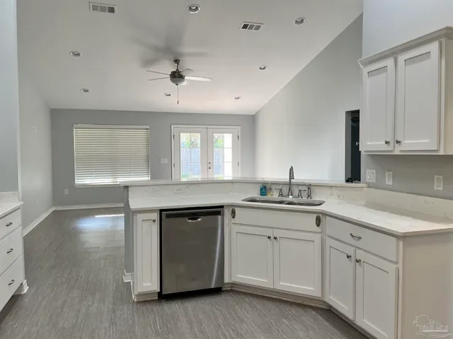 a kitchen with white cabinets and sink