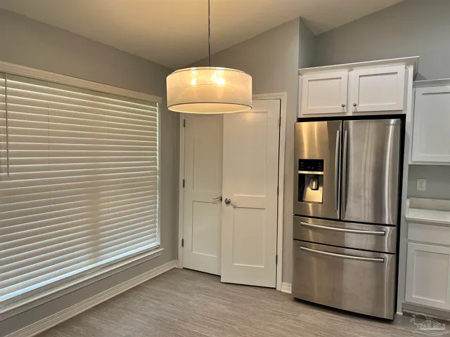 a metallic refrigerator freezer and a wooden floor