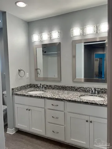a bathroom with double sink and a mirror