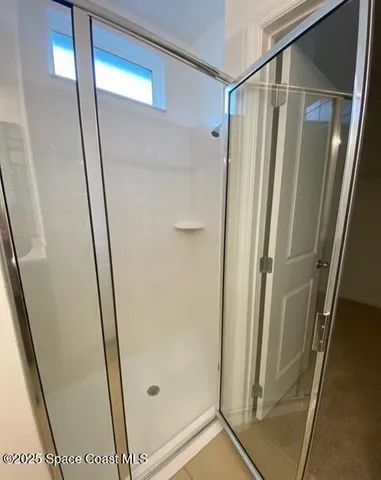 a bathroom with a glass door shower and sink