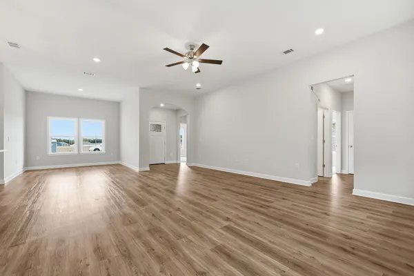 a view of a livingroom with wooden floor and a ceiling fan